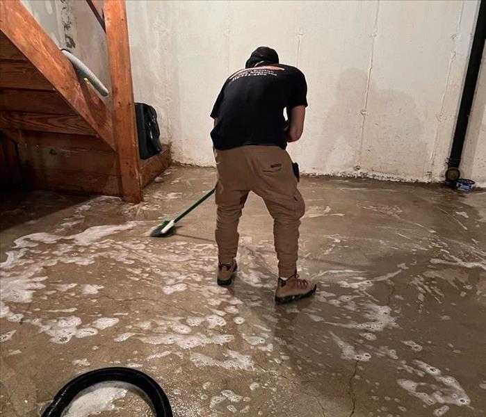 SERVPRO technician sanitizing basement concrete floor