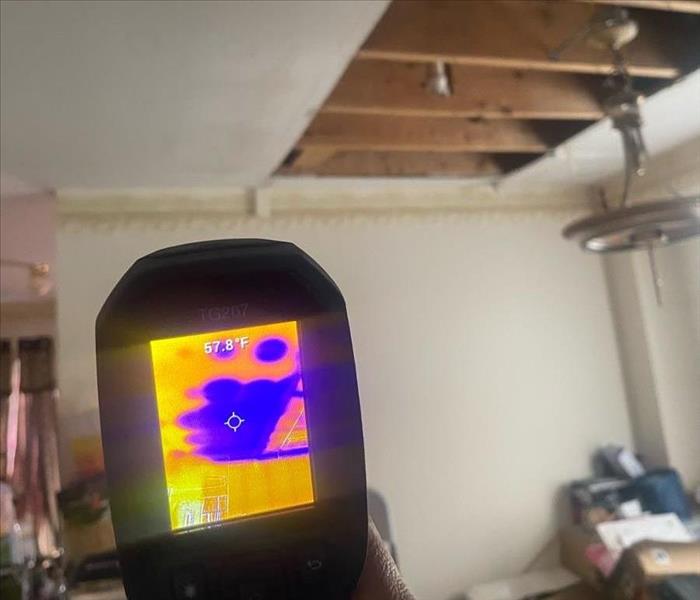 First-person perspective of thermal imaging camera usage for ceiling moisture